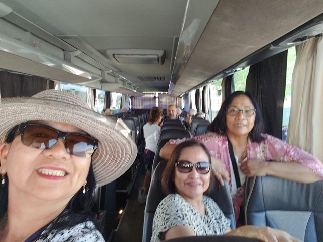       People sitting inside a travel bus.
  