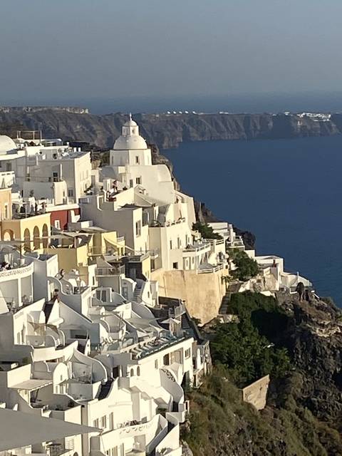       View of white buildings along the coastline.
  