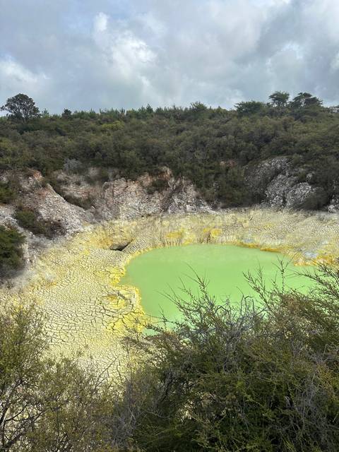       Geothermal lake with mineral deposits surrounding it.
  