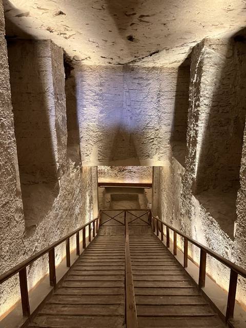 Interior of ancient stone structure with steps leading down.