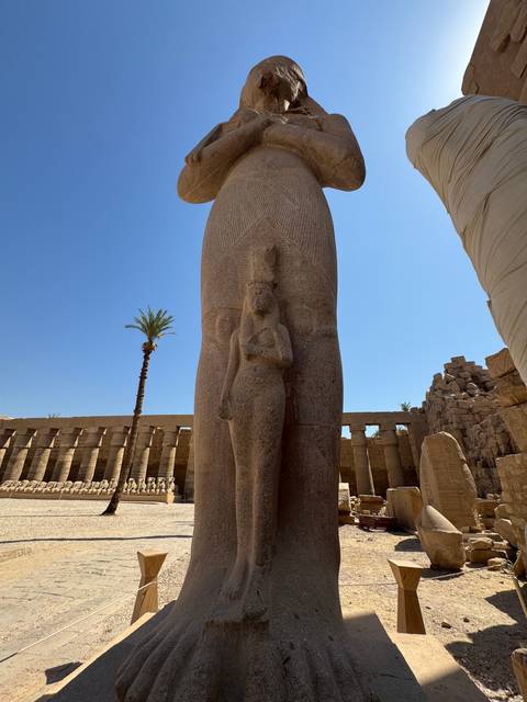       A statue of an ancient Egyptian figure holding a smaller statue.
  