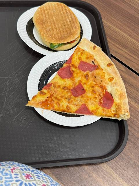       A tray with a slice of pizza and a sandwich.
  