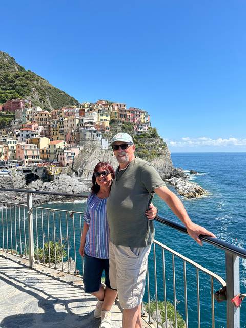 Couple posing with a coastal village in the background.