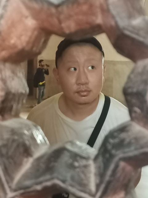       A person standing between two sculptures.
  