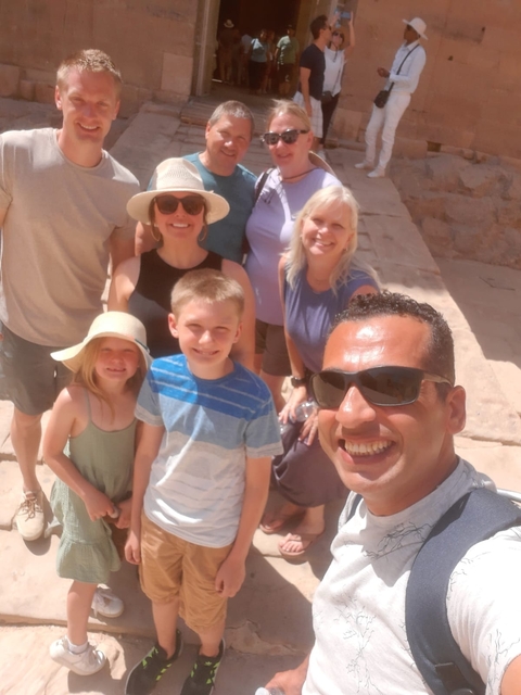 A family posing for a photo in a sunny location.