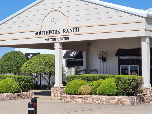 Southfork Ranch Visitor Center entrance with neatly trimmed bushes.