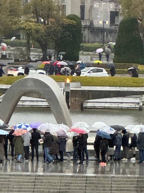 Crowd with umbrellas outside a building during rain.
