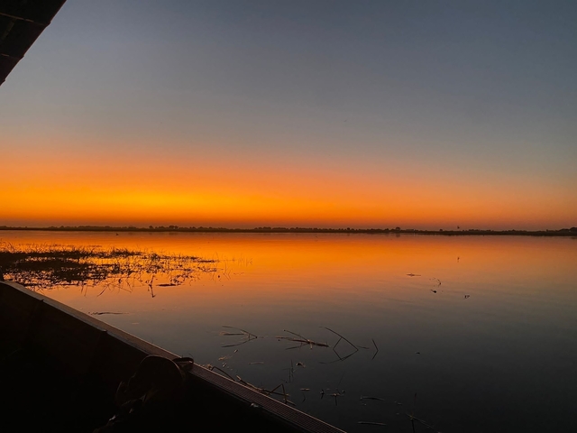      Orange sunset reflecting on a calm river.
  