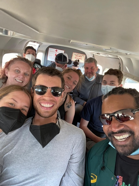       Group of people inside an airplane wearing masks.
  