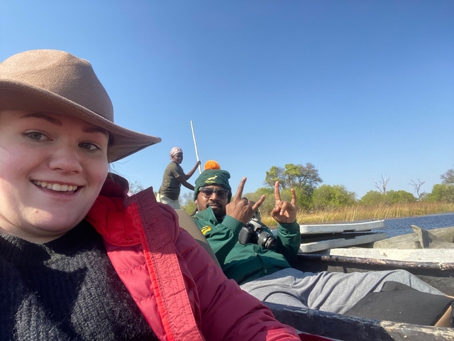       Two people in a small boat on a river.
  