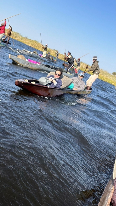       People riding in a small boat on a river.
  