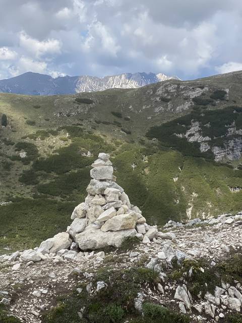 Stacked stones on a grass-covered hillside.