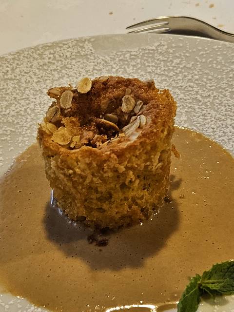 A dessert with oats and sauce on a plate.