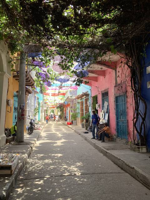       A colorful street with decorations hanging overhead.
  