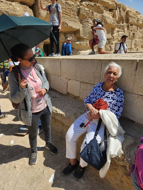 People sitting and talking near ancient ruins.