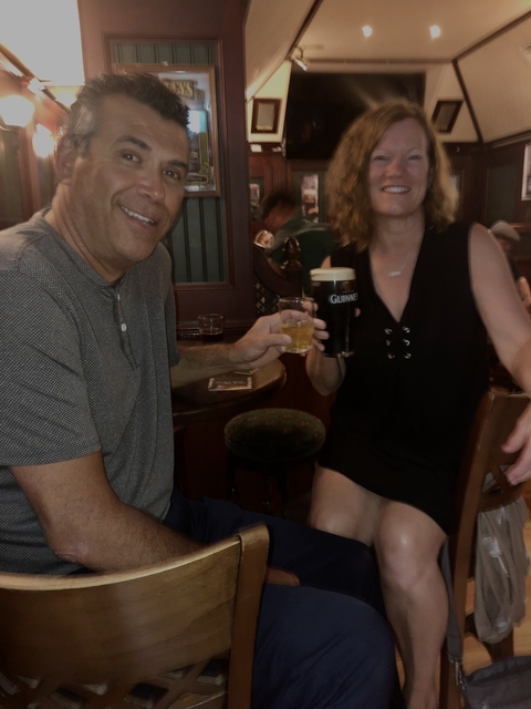 Two people enjoying drinks in an Irish pub.