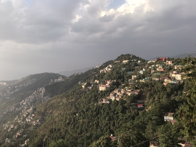       Houses on a hill with cloudy skies
  