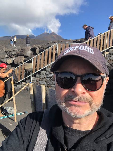       Man taking a selfie with Mount Etna in the background.
  