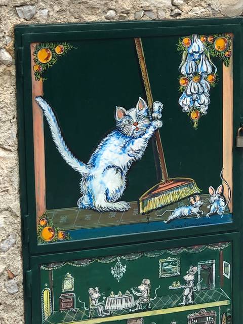      Painted artwork of a playful kitten hanging from a broom.
  