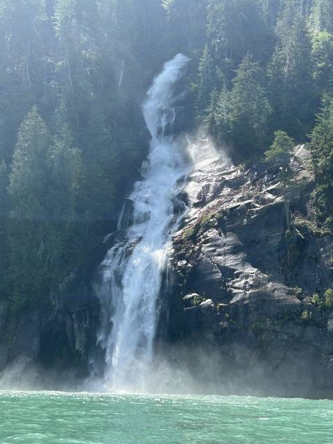 Dramatic waterfall cascading down a rocky cliff with lush greenery.