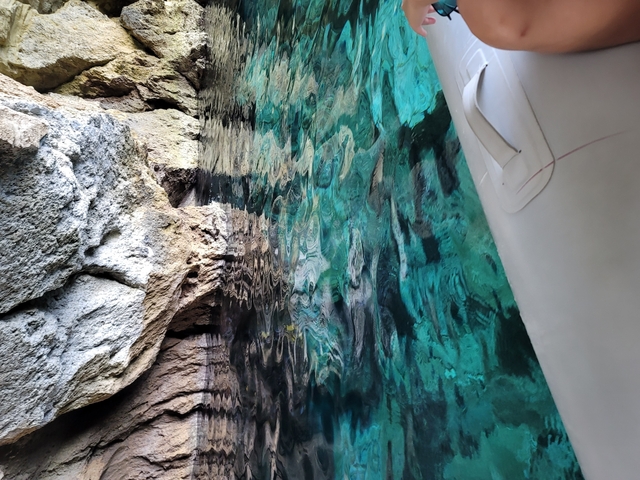       Turquoise water with rocky formations nearby.
  