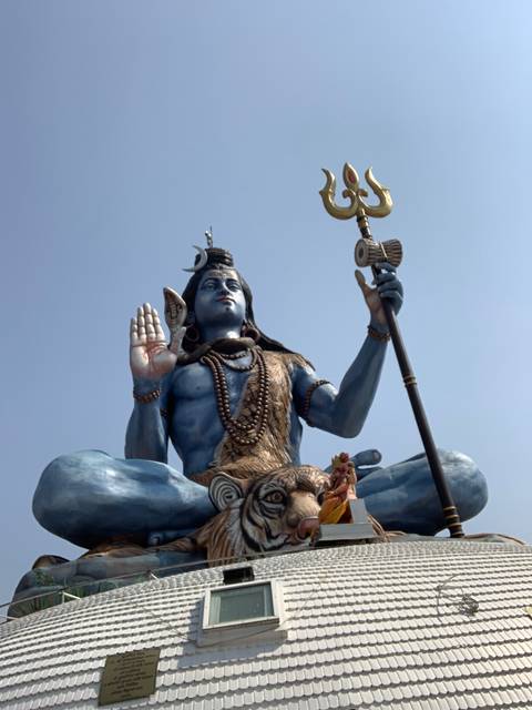       Large statue of a deity holding a trident.
  