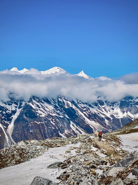       Snow-capped mountains partially covered by clouds.
  