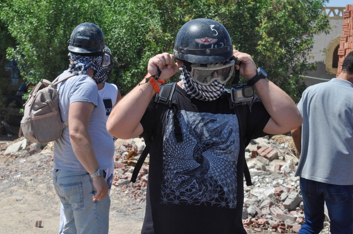 People preparing for an outdoor activity involving helmets and gear.