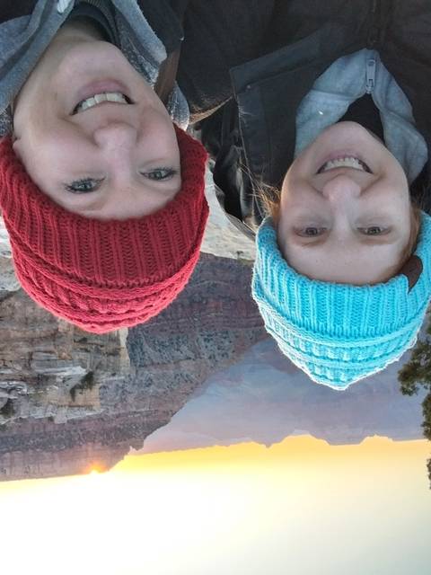       Two people taking a selfie with a scenic canyon view.
  
