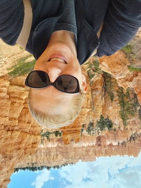 Person taking a selfie with hoodoos in the background.
