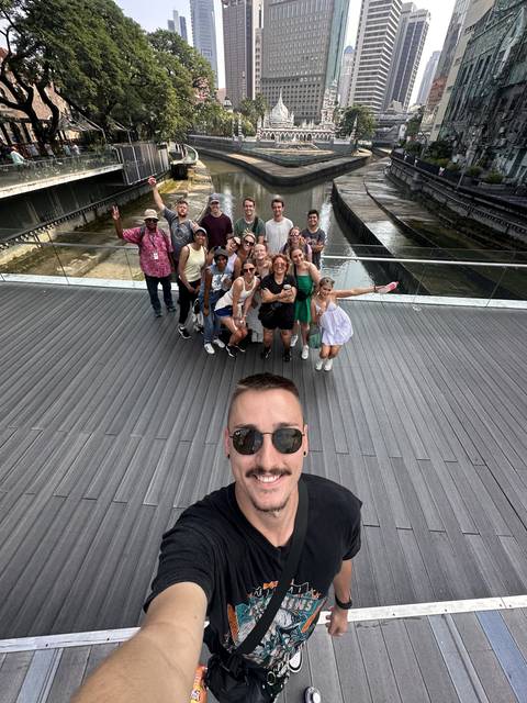 A group of people taking a selfie on a city bridge.