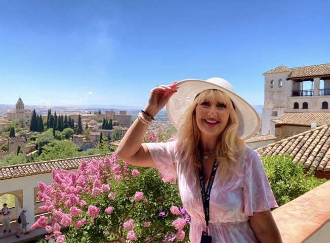 Scenic cityscape with a person and historic buildings in the background.