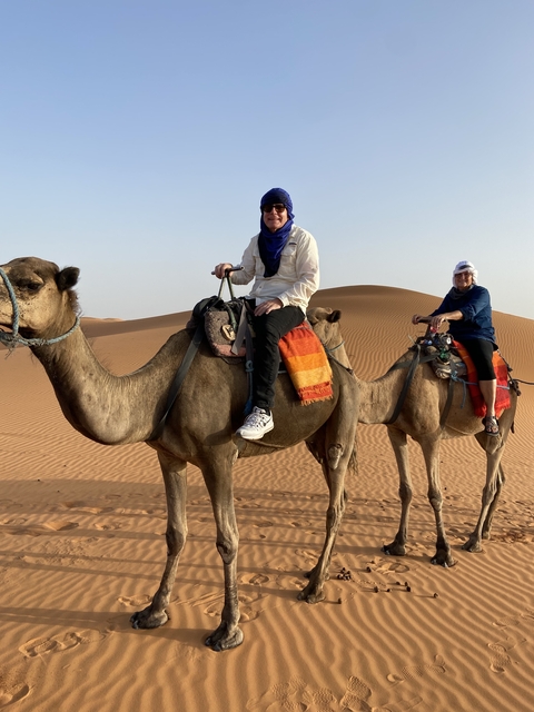Tourists riding camels in the desert.