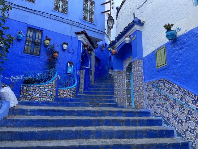 Blue painted stairs and buildings with colorful decorations.