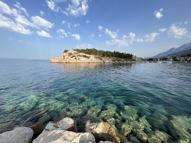       Lighthouse on a rocky promontory by the sea.
  