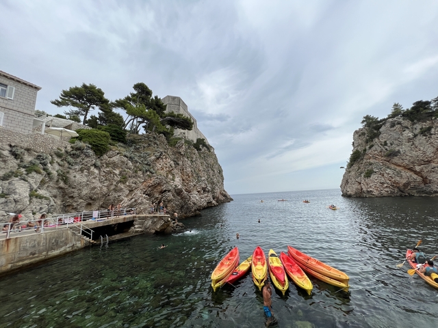       Kayaks in a cove surrounded by cliffs.
  