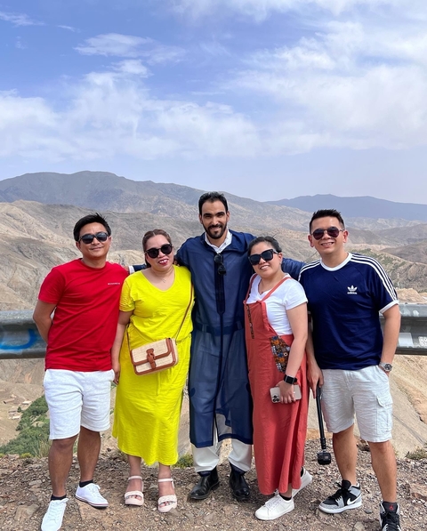       Group photo of five people with mountains in the background.
  