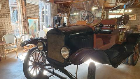       Old model car in a museum setting.
  