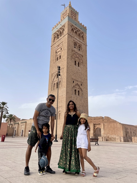 Family posing in front of a tall historic tower.