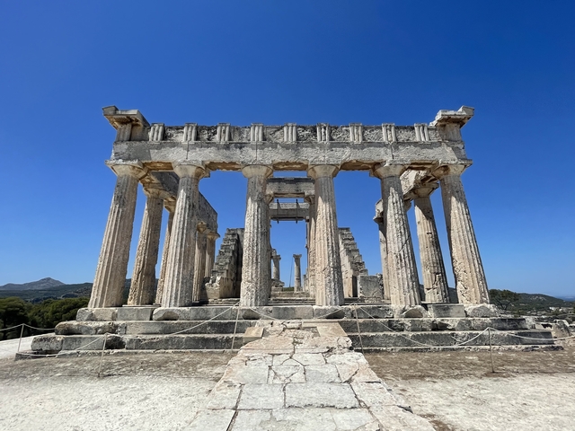       Ancient temple with Greek columns against a blue sky.
  