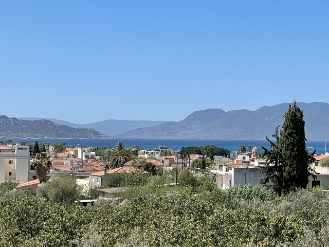       Scenic view of a coastal town with mountains in the background.
  