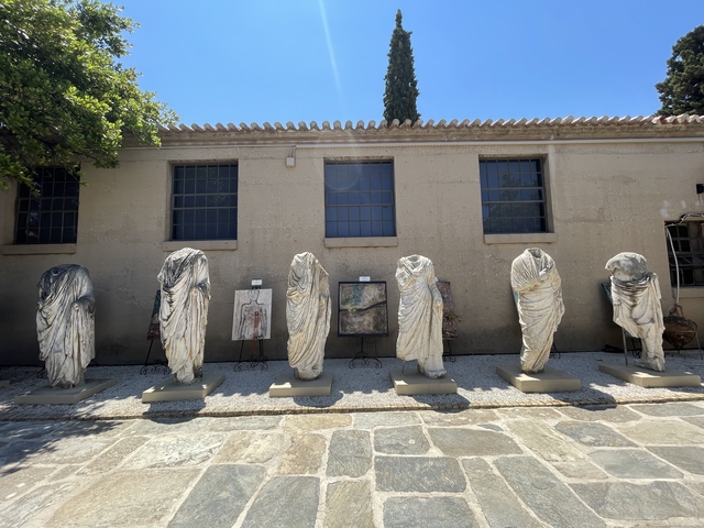       Outdoor museum display with ancient sculptures lined up.
  