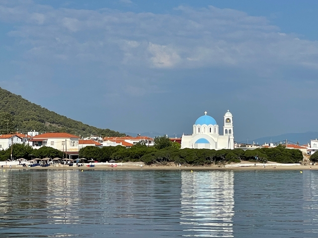       Picturesque church with blue domes by the sea.
  