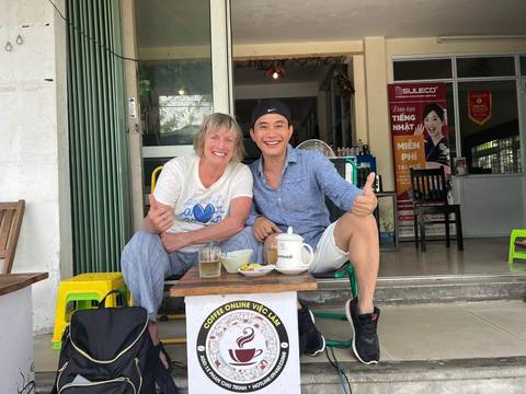Two people sitting at a table with drinks and food.