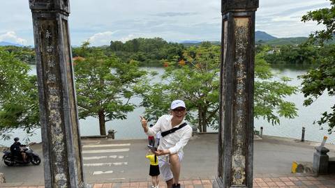 Person posing playfully in front of a river.
