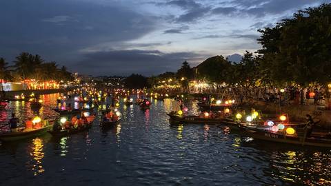River illuminated with colorful lanterns at night.