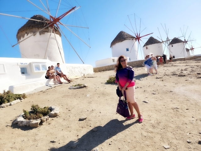       Woman posing near iconic windmills.
  