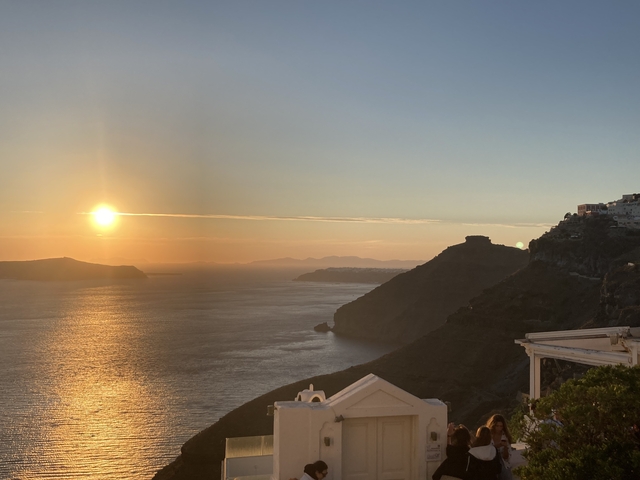 Sunset over the ocean with cliffside views.