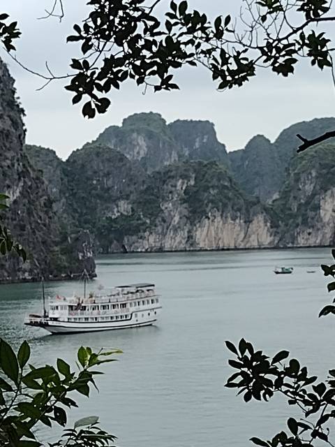 A boat cruising on a bay with rocky formations.