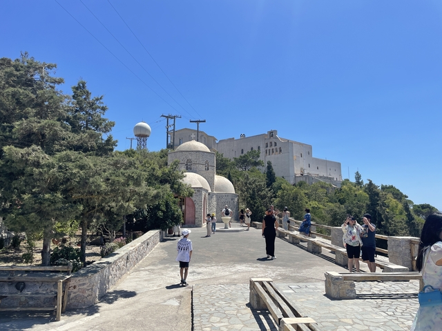       Tourists visiting a historical site with a church and fortress.
  
